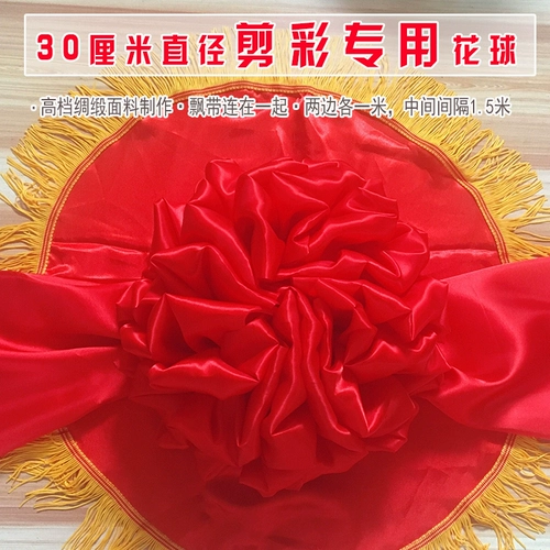 Открытая лента срезает большой красный цветок мяч из золотого дракона и феникса ножниц.