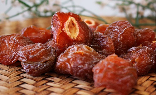 Половина сливы и половина высушенной сливы.